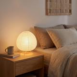 Halden Japanese Lantern Lamp glowing on a bedside table