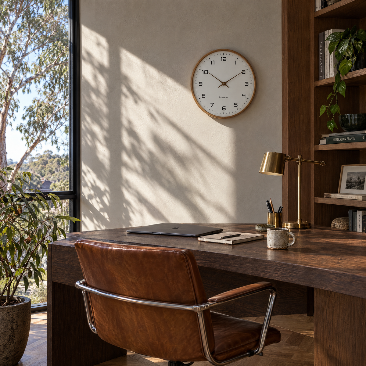 Brown wood frame silent wall clock above a home office desk
