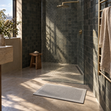 Light grey quick-dry bath mat outside a walk-in shower