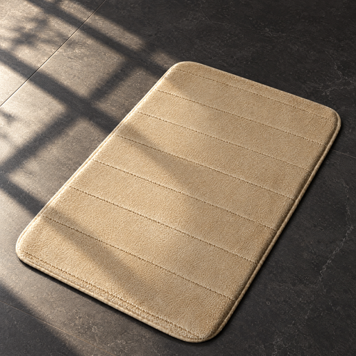 Khaki plush anti-slip bath mat on a sunlit dark stone bathroom floor