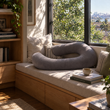 Grey U-shape pregnancy pillow as a backrest on a window seat reading nook