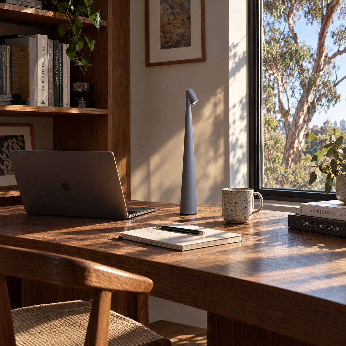 Grey cordless LED table lamp on a home office desk