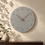 Nork minimalist wall clock in grey on a sunlit plaster wall
