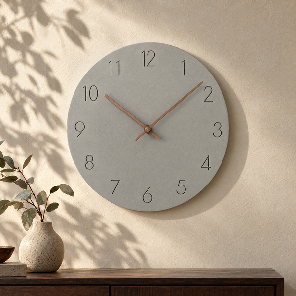 Nork minimalist wall clock in grey on a sunlit plaster wall
