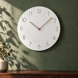 Nork minimalist wall clock in white on a deep green plaster wall