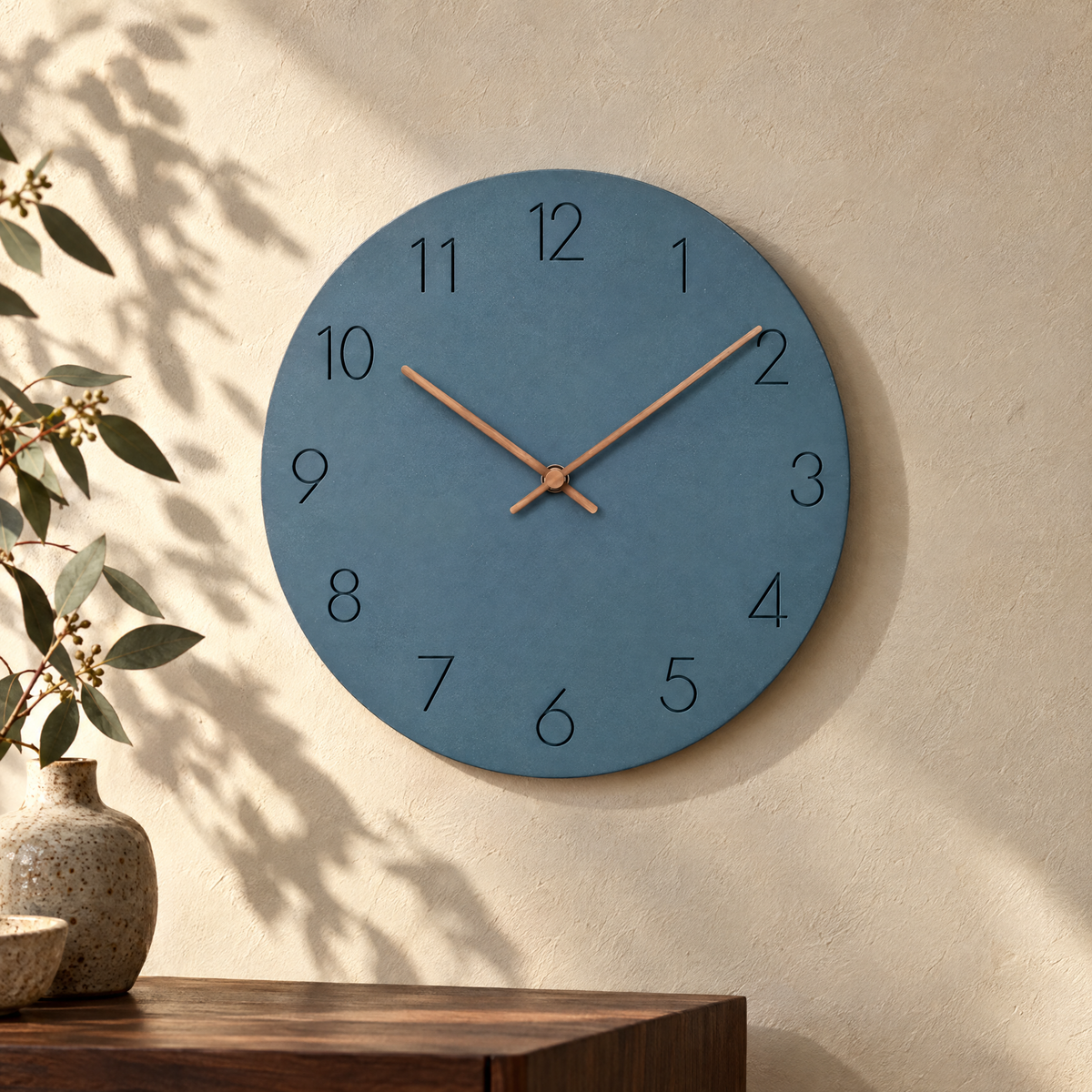 Nork minimalist wall clock in blue on a sunlit plaster wall