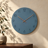 Nork minimalist wall clock in blue on a sunlit plaster wall