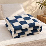 Ruta Checkered Plaid Blanket folded on a bed