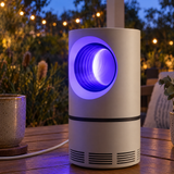 UV insect killer lamp glowing on a terrace table at dusk
