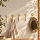 Krok brass wall hooks on a limewashed hallway wall