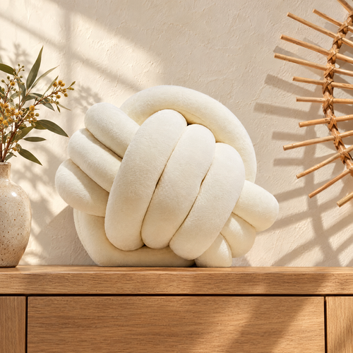 Knut cream velvet knot cushion on an oak sideboard