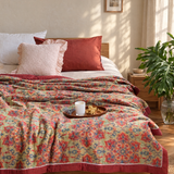 Floral cotton gauze summer blanket on an oak bed